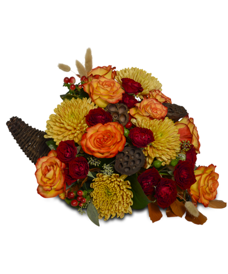 Thanksgiving cornucopia with bronze mums, orange roses, red carnations, lotus pods, berries, greenery, and autumn leaves in a woven horn of plenty basket
