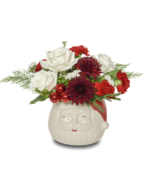 Santa Smiles floral arrangement with white roses, red carnations, and burgundy mums arranged in a cheerful Santa Claus vase with holiday greenery.