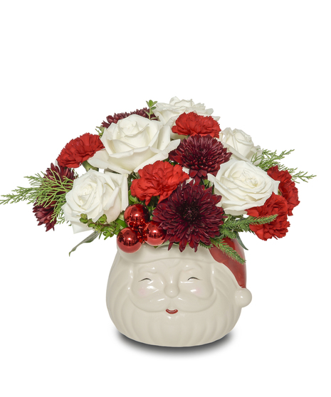 Santa Smiles floral arrangement with white roses, red carnations, and burgundy mums arranged in a cheerful Santa Claus vase with holiday greenery.