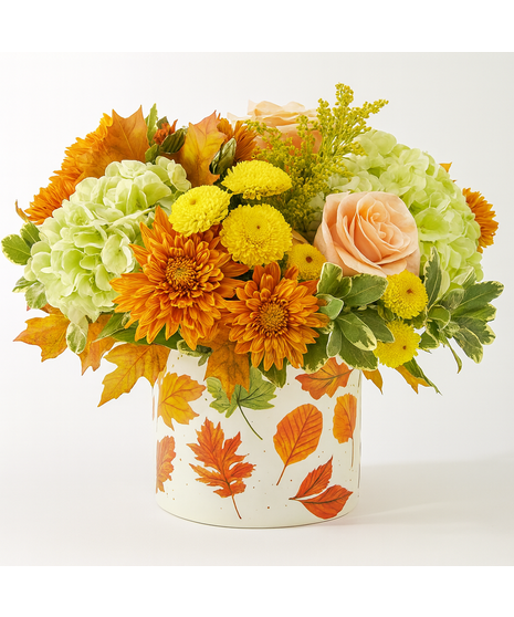Maple Medley floral arrangement featuring peach roses, green hydrangeas, orange mums, and fall leaves in a leaf-patterned pot.