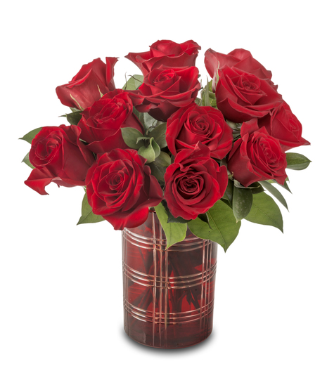 A compact arrangement of red roses accented with white baby’s breath and greenery, designed in a small vase and standing approximately 12–14 inches tall.