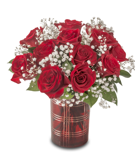 A compact arrangement of red roses accented with white baby’s breath and greenery, designed in a small vase and standing approximately 12–14 inches tall.