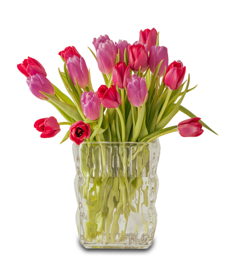 A romantic arrangement of pink and red tulips with green stems displayed in a clear textured glass vase against a white background.