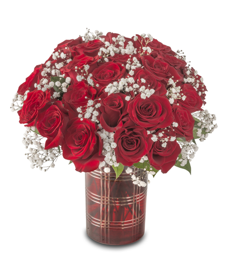 A compact arrangement of red roses accented with white baby’s breath and greenery, designed in a small vase and standing approximately 12–14 inches tall.