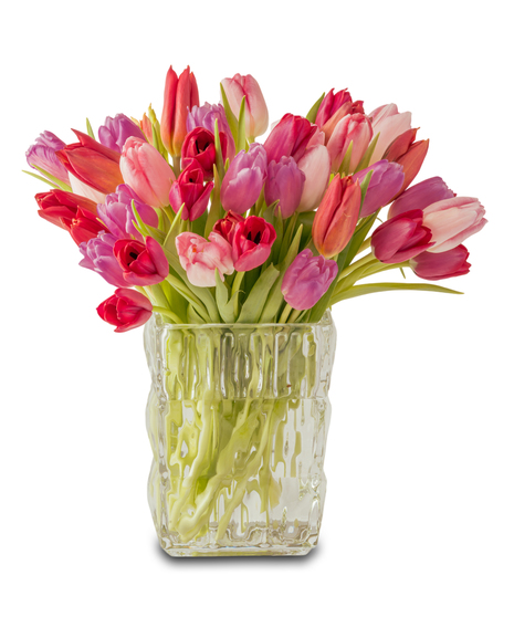 A romantic arrangement of pink and red tulips with green stems displayed in a clear textured glass vase against a white background.