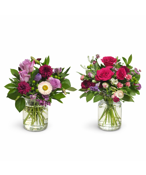 Seasonal mixed flower arrangement with three roses and fresh accent blooms in a 5-inch clear glass cylinder vase with lemon leaf greenery.