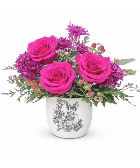 Bunny pot filled with hot pink roses, purple mums, hypericum berries, lavender limonium, and statice.
