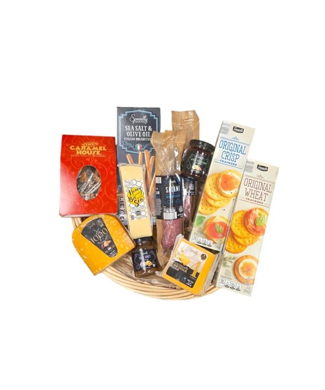 Wicker basket filled with gourmet foods including cheeses, salami, crackers, spreads, honey cheddar , and chocolate toffee arranged neatly for gifting.