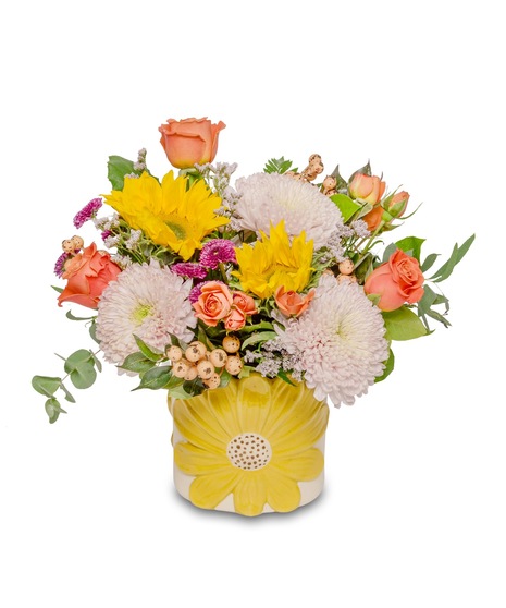 Vibrant arrangement in sunflower-adorned pot: prominent golden sunflowers, orange standard and miniature roses, fall mums, and berries. Deluxe version has more blooms.