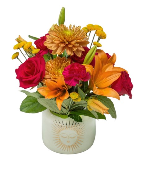 Two floral arrangements in white ceramic vases with golden sun design, filled with bright yellow, orange, and pink flowers. Available in two sizes.