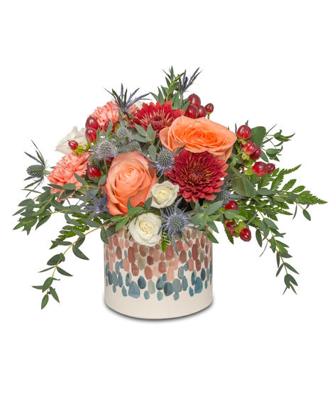 Celebrate' design with red chrysanthemums, orange roses, and miniature roses in a dot-decorated pot—perfect for celebrations.